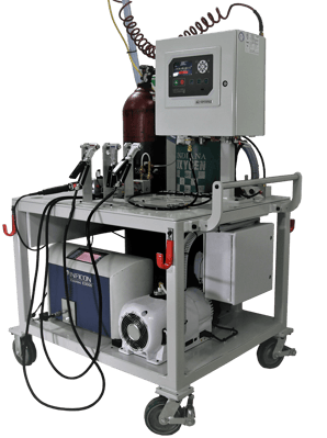 Image shows a TracerMate II tracer gas leak test system, three purging clamshells, and other equipment on a cart.