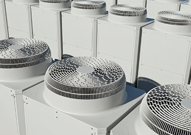 Close-up of commercial heating and cooling systems on the rooftop of a building. 