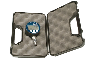 Image shows vacuum/pressure  gage with digital screen showing 0.0, on the left side inside an open padded case.