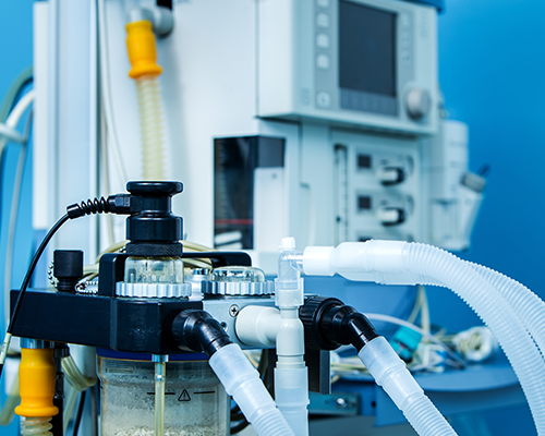 Image shows an anesthesia ventilator workstation, with respiratory tubing in the foreground.