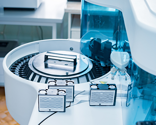 Image shows an analyzer for immunochemical analysis with reagent cartridges in the foreground.