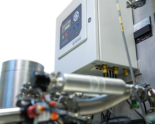 Image looking up at a TracerMate II mounted on a wall with canisters in foreground.